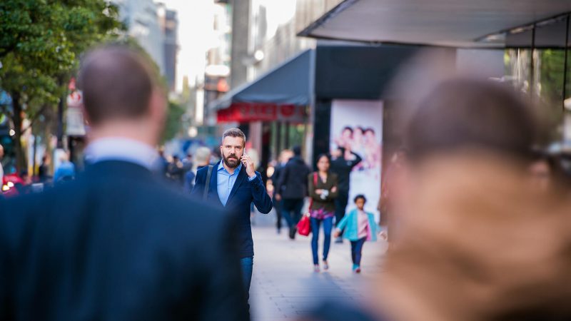 hipster-manager-with-smart-phone-walking-in-the-PFKTPR9(1)